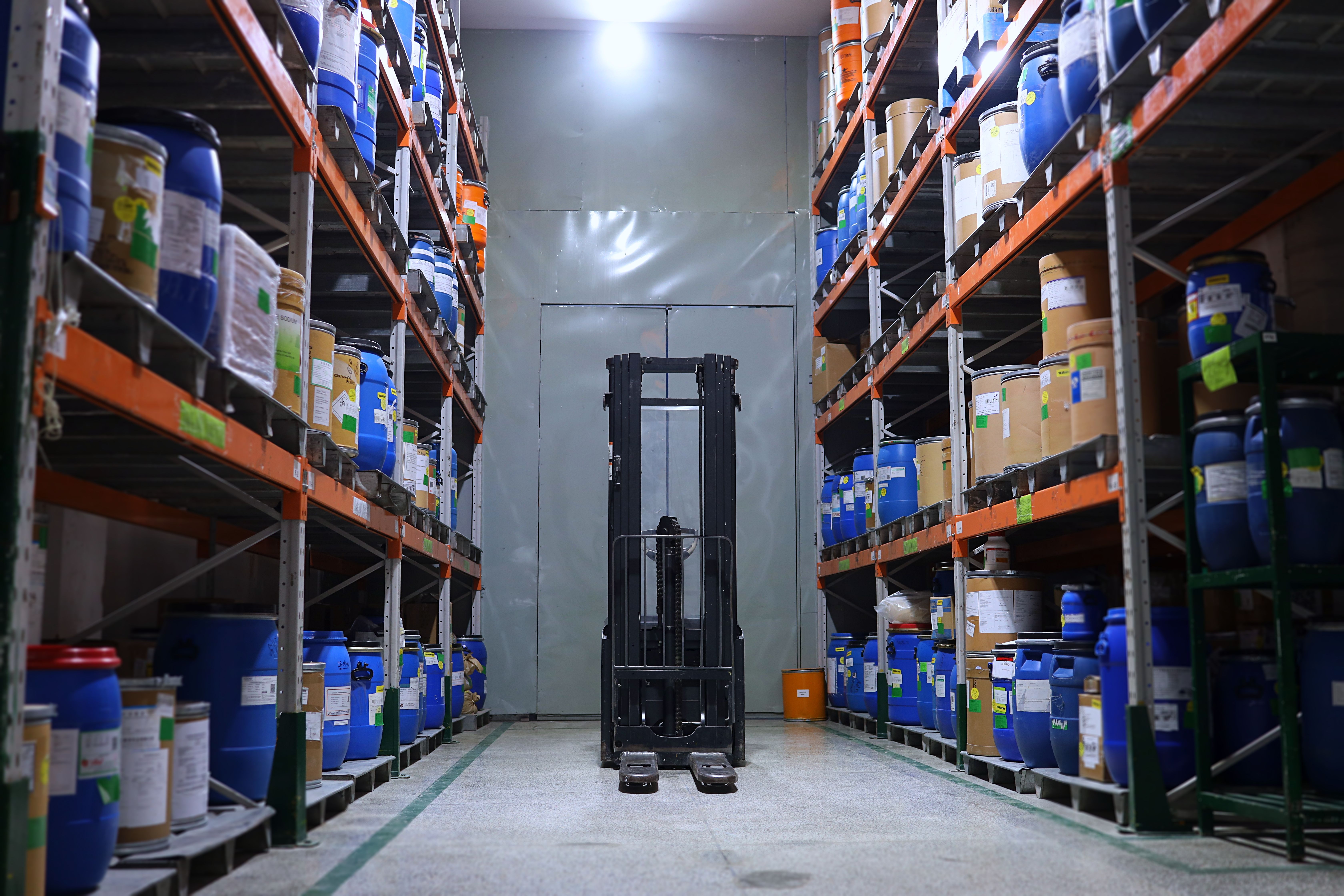 Forklift depo koridorunda raflar arasında çalışıyor