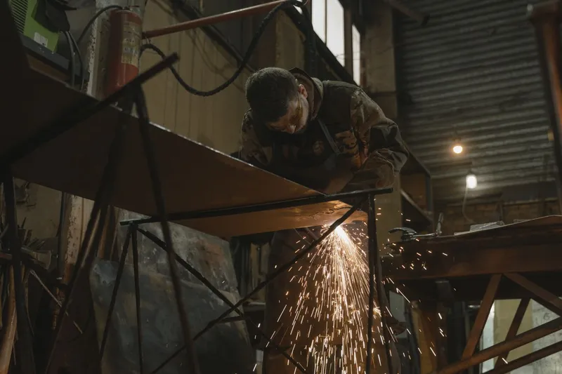 Atölyede metal işçisi kıvılcımlar arasında çalışıyor