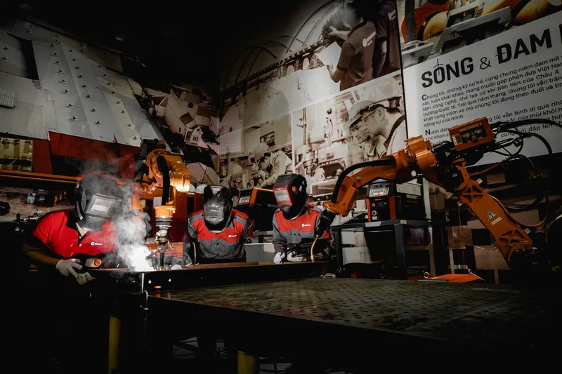 Kaynakçılar robotik kaynak kolu ile aynı istasyonda çalışıyor